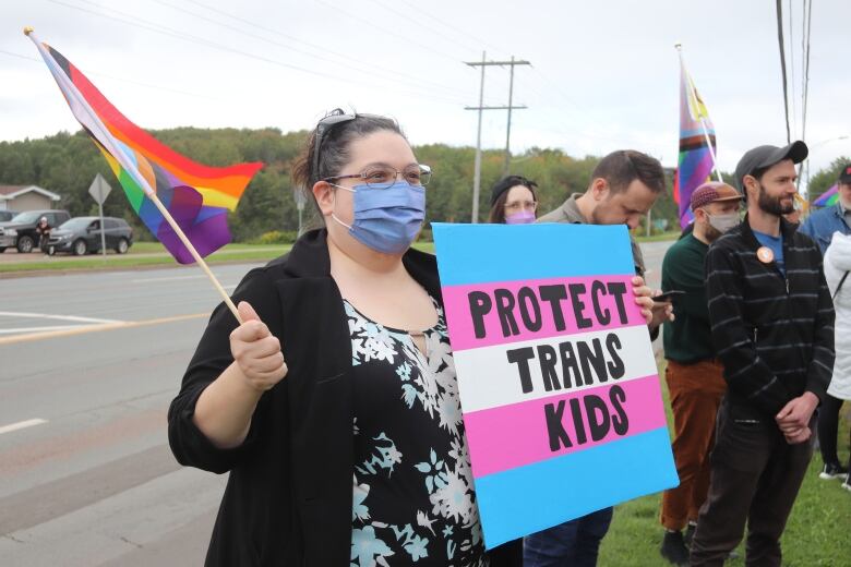 Denise Roy-Loar  holds pride flag and sign saying 