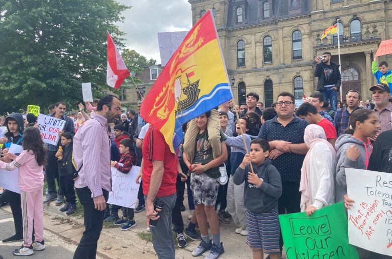 A crowd of people holding signs and flags