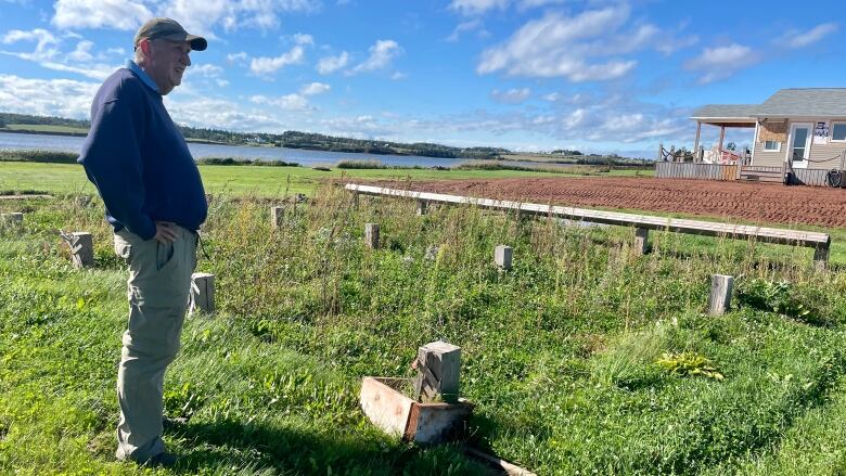 Jim Randall looks at the spot on his waterfront property where his cottage once stood.  All that remains there now are wooden posts. 