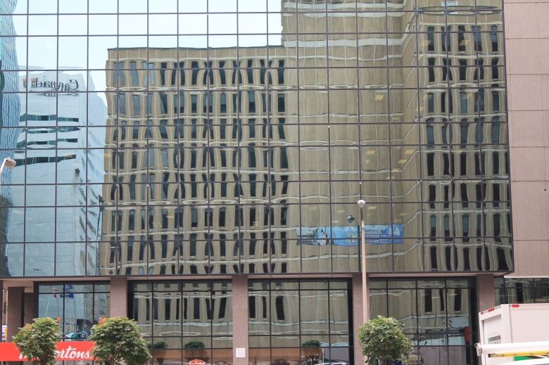 A brutalist building viewed in a window reflection.