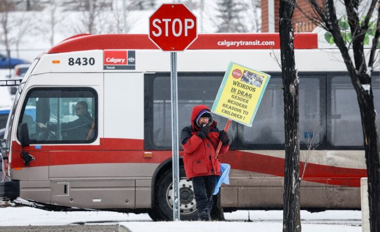 A man with a sign stands in the snow. 