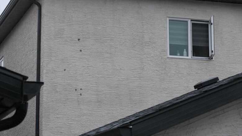 Holes can be seen on the exterior of a home on Hazelton Drive where Sukhdool Singh Gill was found dead by Winnipeg police on Sep.20, 2023.