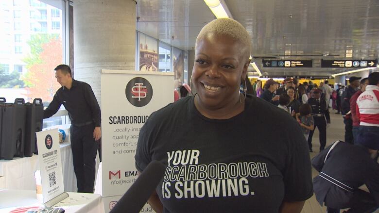 A woman stands in a transit station.