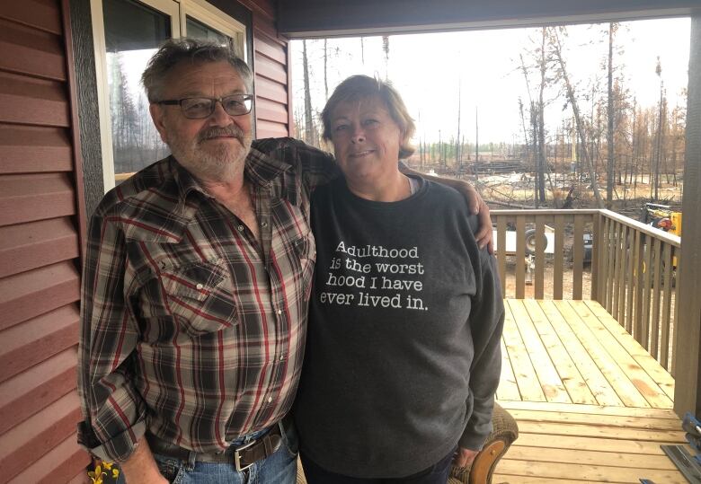 Pat and Evelyn Coleman were one of the lucky ones in Enterprise who were able to return to a home left untouched by the flames. In this photo, they are standing on their front deck.