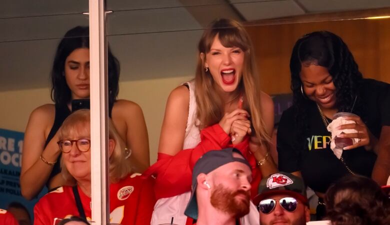 A woman cheers at a football game.