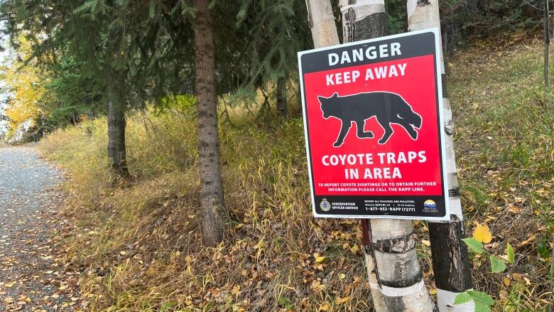 A sign that reads danger keep away coyote traps in area