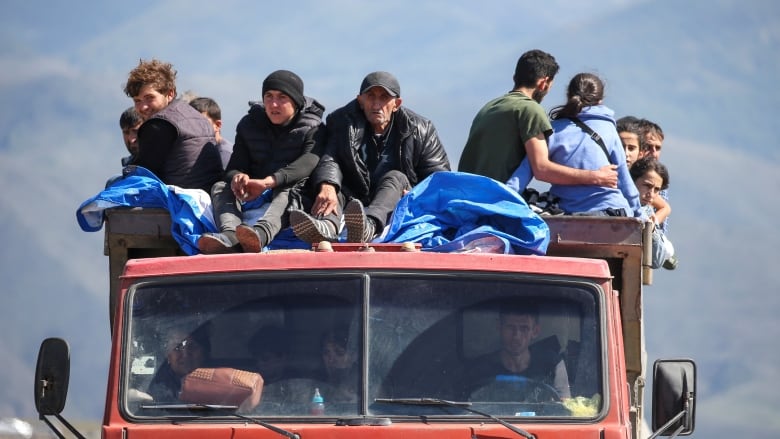 Refugees from Nagorno-Karabakh region ride in a truck upon their arrival at the border village of Kornidzor, Armenia, September 27, 2023.