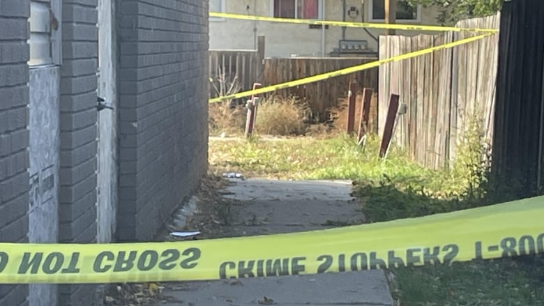 yellow police tape blocks a walkway