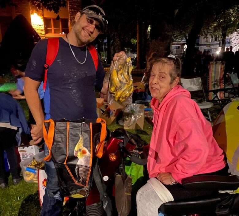 Two people are outside carrying food.