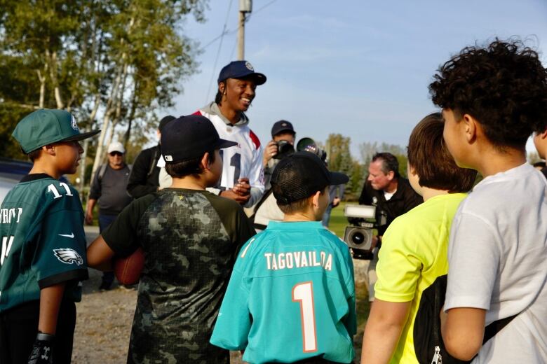 Kids surround Kaion Julien-Grant.