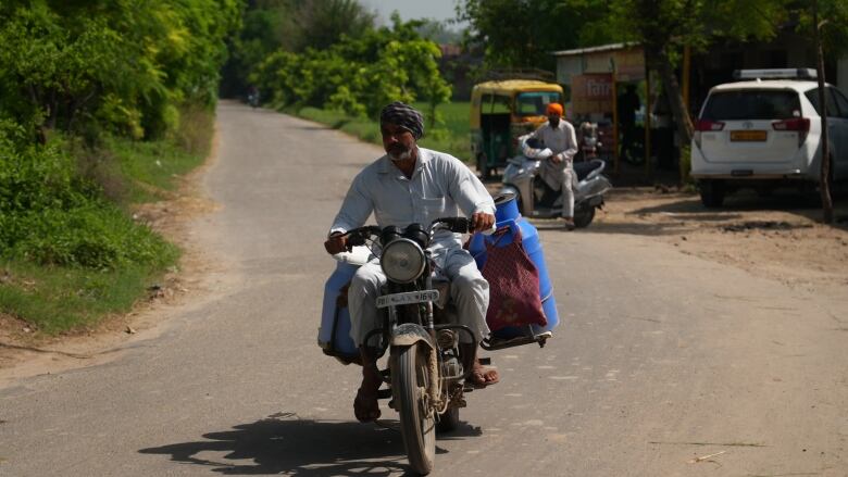 A person rides a scooter on a rural road.