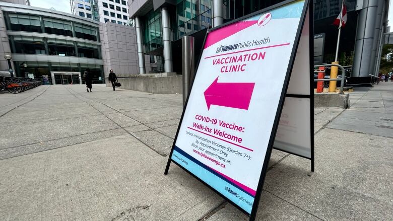 Sign outside Toronto's Metro Hall promoting a vaccination clinic for COVID-19 and school immunizations. 