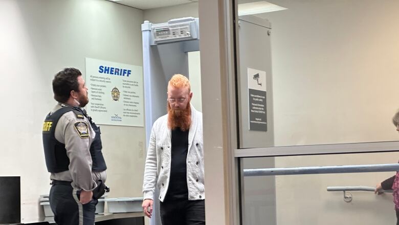 A man walks through a metal detector.