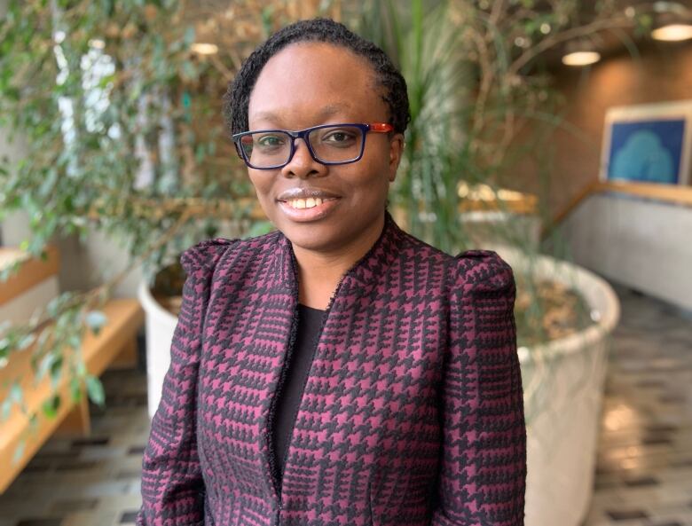 A woman wearing glasses smiles. 