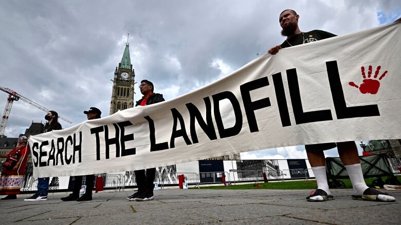 People rally on Parliament Hill on an International Day of Action to Search the Landfills on Sept. 18, 2023.