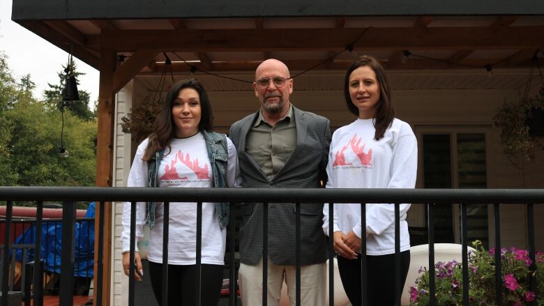 Paige Petuh-Bowman, Cole Izsak, and Desiree Belisle stand on the back porch of The Castle, a planned recovery facility awaiting business licensing from the City of Surrey.