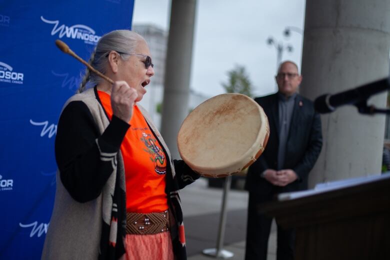 Theresa Sims performs outside of Windsor's City Hall while playing the drum. 