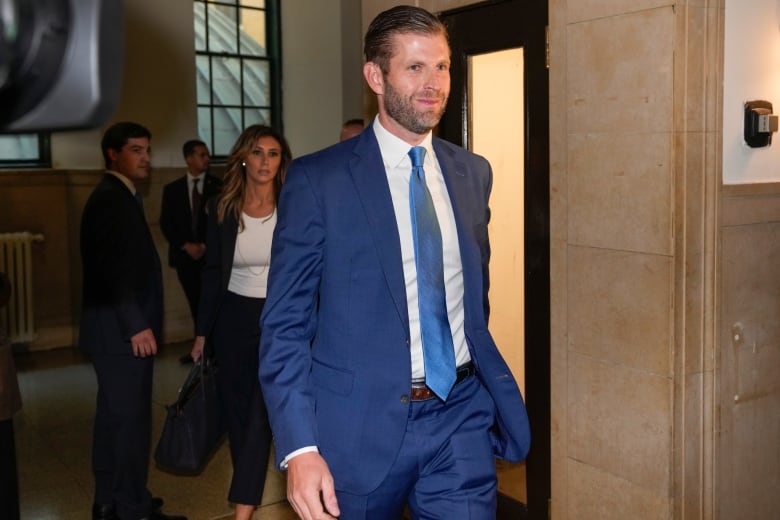 A man in a suit and tie is shown walking inside a building.