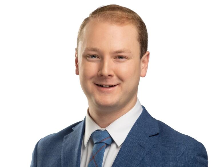 A headshot of a young white man. 