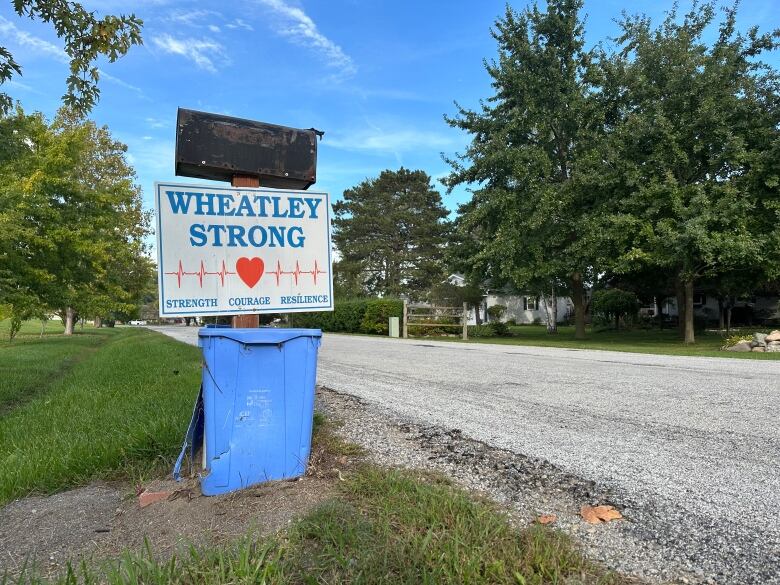 A sign on a lawn reads, 'Wheatley Strong. Strength. Courage. Resilience.'