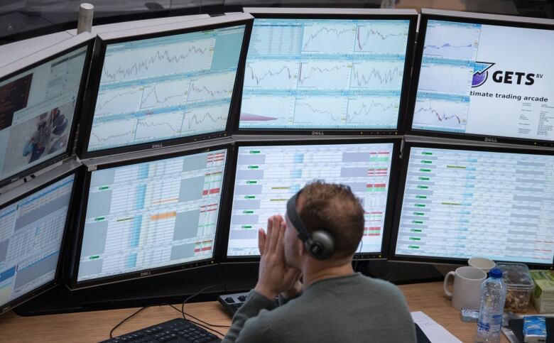 A financial trader monitors data on computer screens on the trading floor inside the Amsterdam Stock Exchange