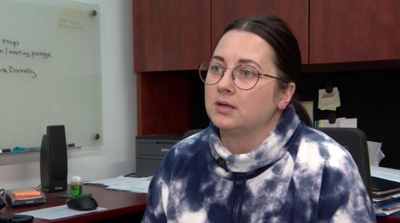 A woman in a purple and white hoodie.