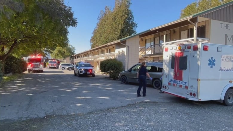 An ambulance, police car and fire truck are parked by a motel in Chilliwack, B.C.