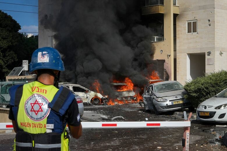 Black smoke rises from burning cars.