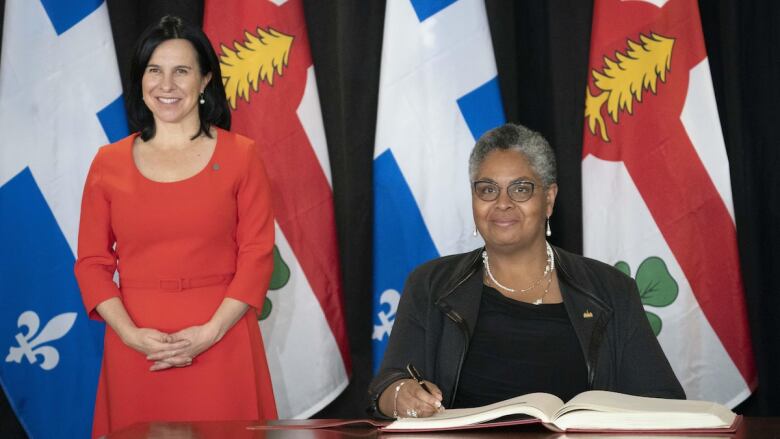 Two woman behind a desk.