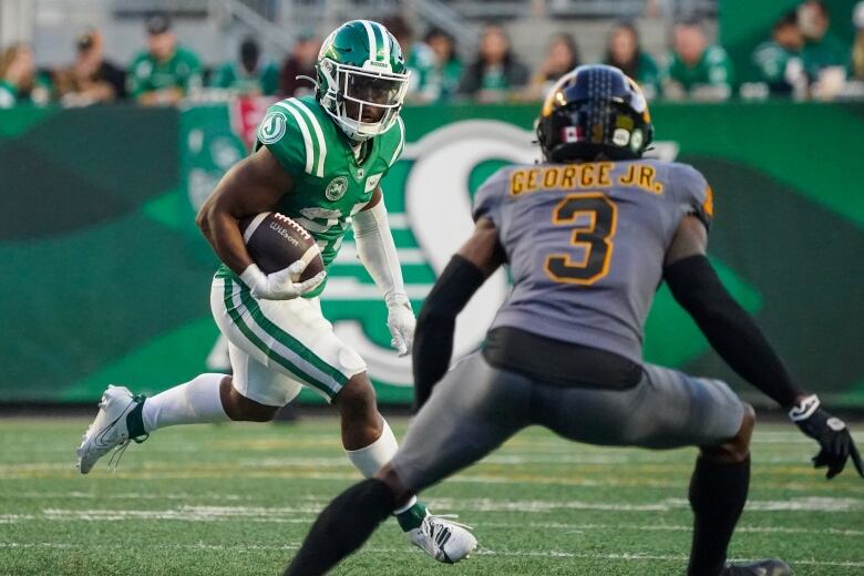 Two football players trying to catch the ball.