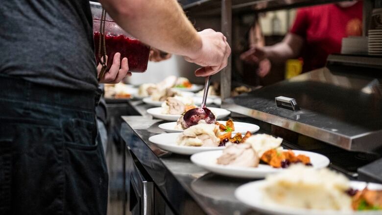 A chef can be seen plating Thanksgiving dishes. 