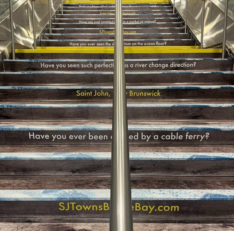 A flight of stairs in the Toronto PATH featuring an ad for cable ferries. 