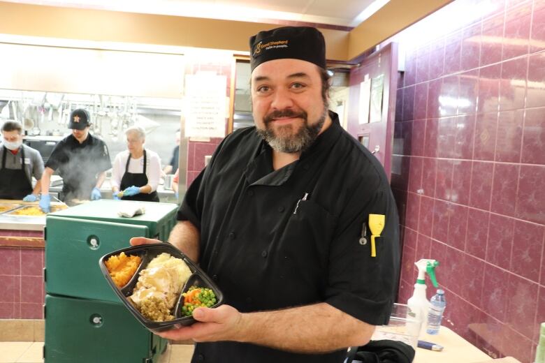 Man holding a Thanksgiving dinner. 