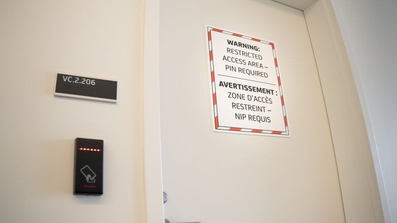 A door at a security agency with a sign talking about restricted access.