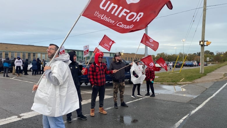 Union members carry signs on a picket line.