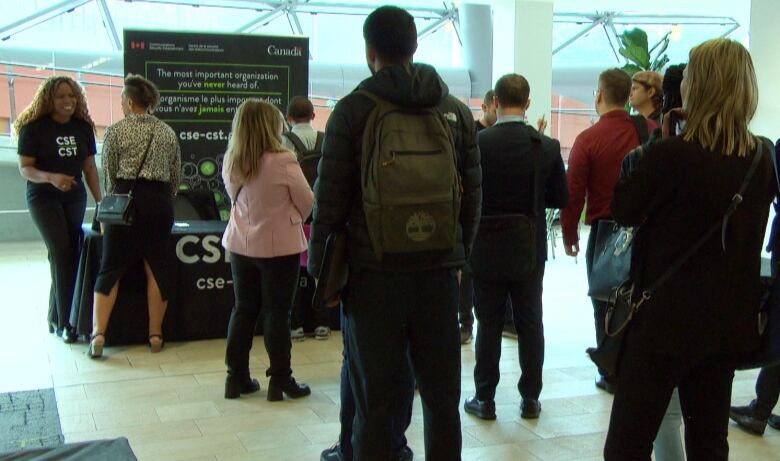 People line up at a table at a job fair.