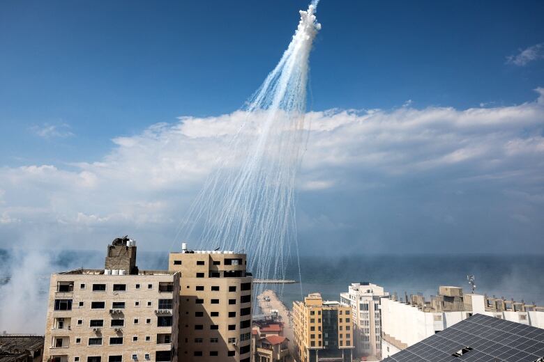 A trail is shown in the sky from fire during a war-like attack.