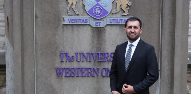 Man in front of Western University sign. 