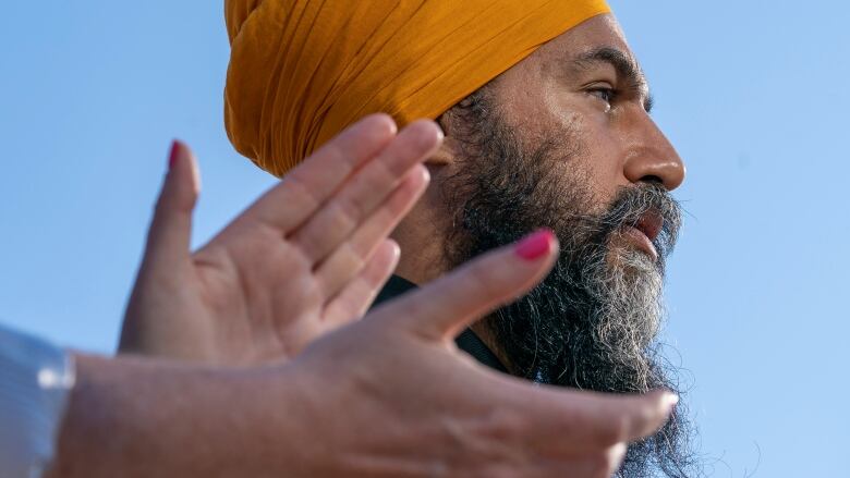 A woman applauds as New Democratic Party Leader Jagmeet Singh does his morning announcement during an election campaign stop in Hamilton, Ont., Monday, Sept. 6, 2021.  THE CANADIAN PRESS/Jonathan Hayward