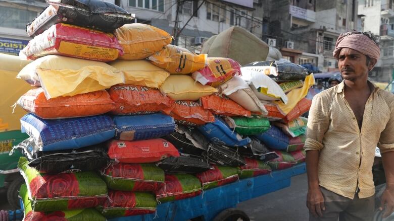 A man delivers grains and pulses to a wholesale vendor at a market in Old Delhi on Oct 9, 2023.