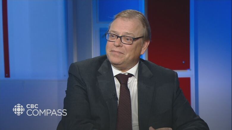 Dr. Mike Howlett sits at a desk with Compass host Louise Martin.