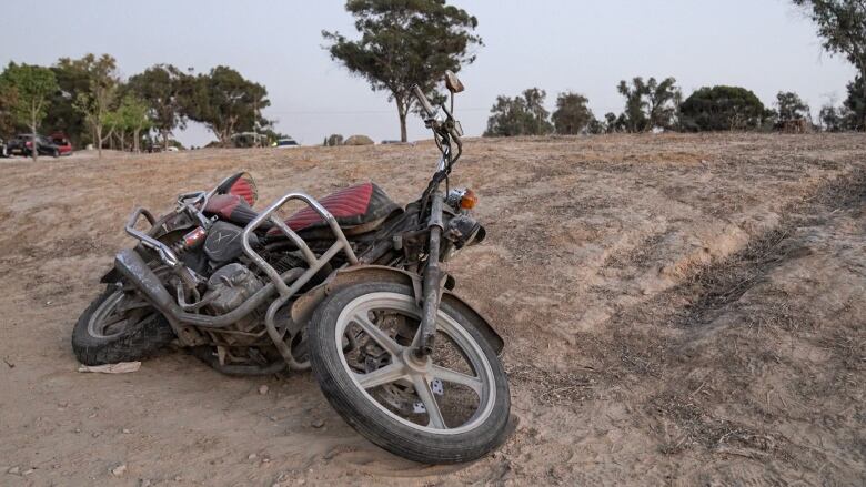 An abandoned motorcycle in a field.