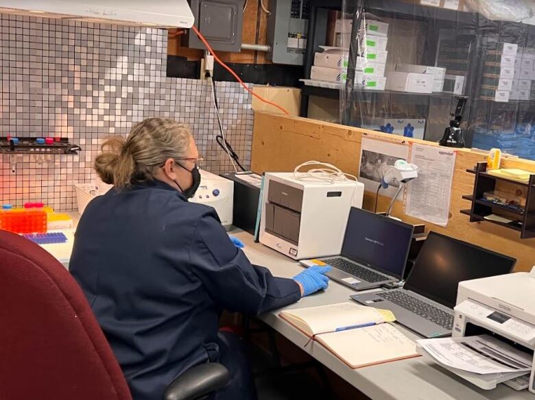 A person working at a desk with a mask on.