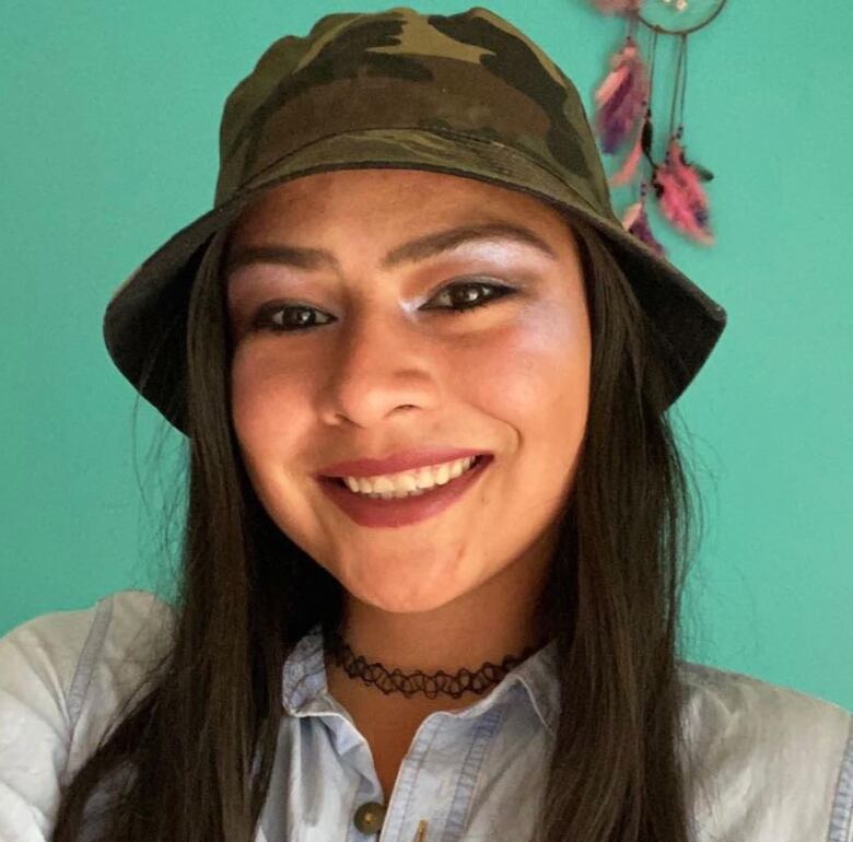 A close-up photo of a woman wearing a camouflage bucket hat is shown.