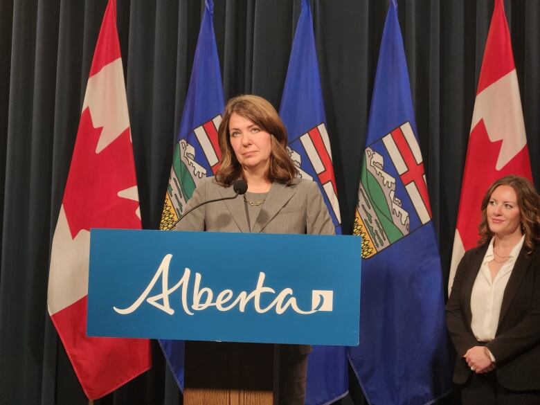 A woman stands behind a podium.