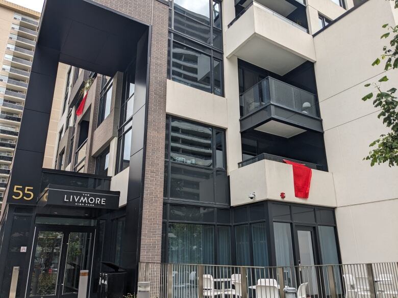 Red flags hanging off a balcony on a modern apartment building.