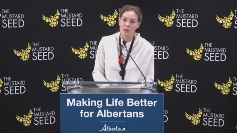 A woman is pictured behind a podium.