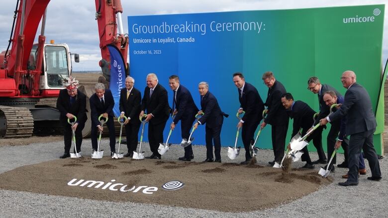 people posing with shovels in hand