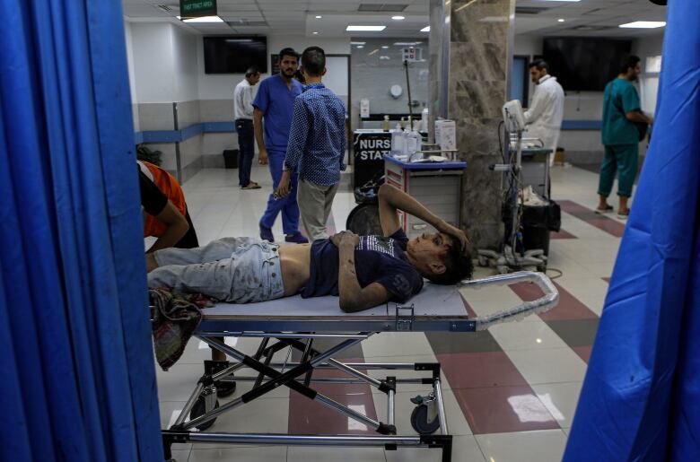 A wounded boy lies on a guerney in the emergency room of al-Shifa hospital, in the aftermath of Israeli airstrikes on Gaza City.