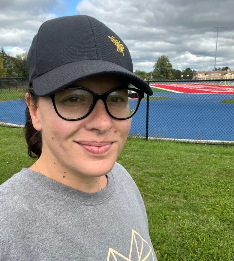 A woman wearing glasses and a baseball cap.